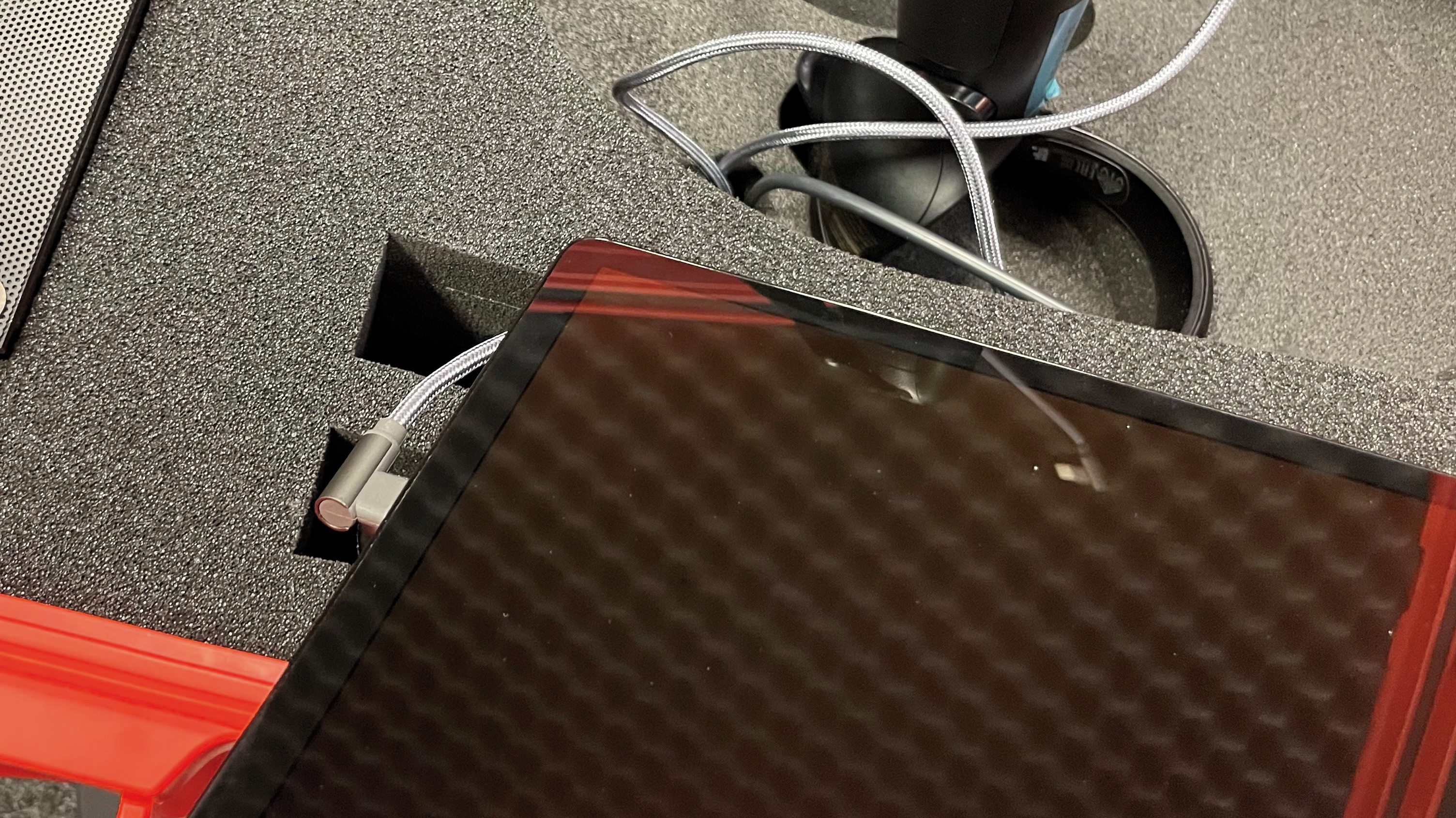 Tablet po wyjęciu z kieszeni skrzyni FLORIANVR. Widoczny wetknięty przew&oacute;d zasilający w gnieździe ładowania.