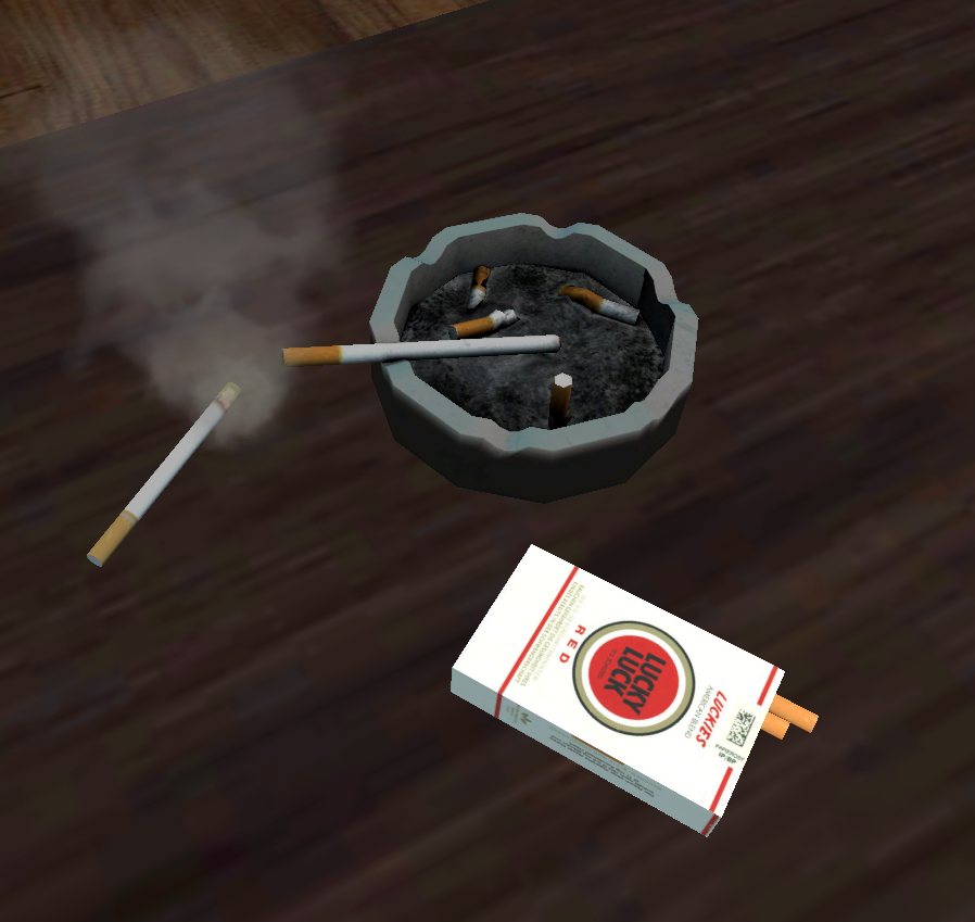 Niedogaszone papierosy w popielniczce i pudełko papierosów.